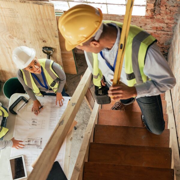 Top view, construction building and team planning with blueprint, collaboration and conversation. A